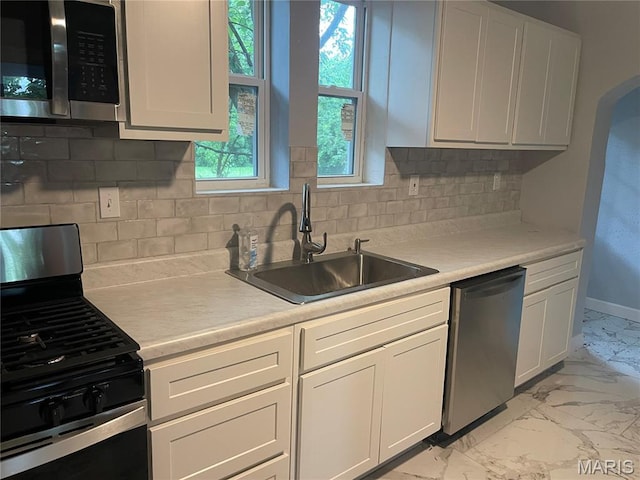 1432 Tamerton Ave, Overland, MO 63132 - kitchen with appliances with stainless steel finishes, light marble finish flooring, decorative backsplash, light countertops, and white cabinets