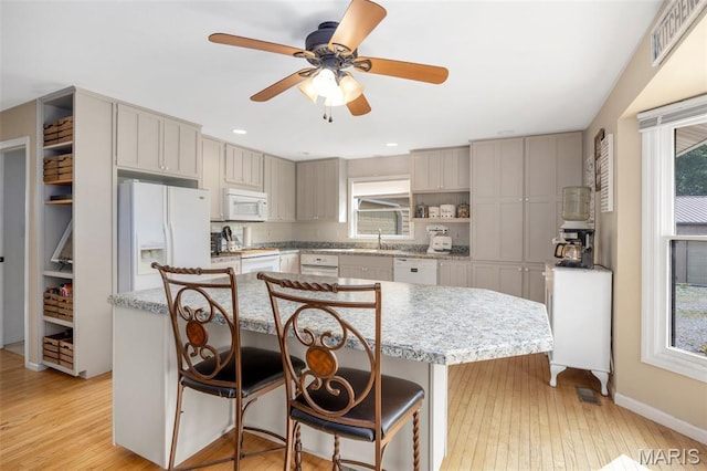 795 Schluersburg Rd, Augusta, MO 63332 - kitchen featuring white appliances, a sink, a kitchen island, open shelves, and a breakfast bar