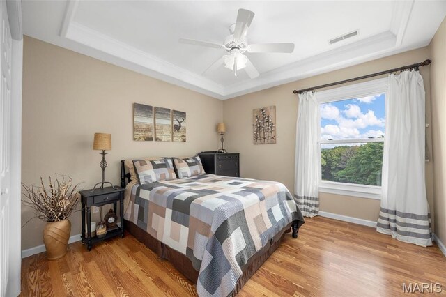 795 Schluersburg Rd, Augusta, MO 63332 - bedroom featuring a raised ceiling, light wood-type flooring, baseboards, crown molding, and a ceiling fan