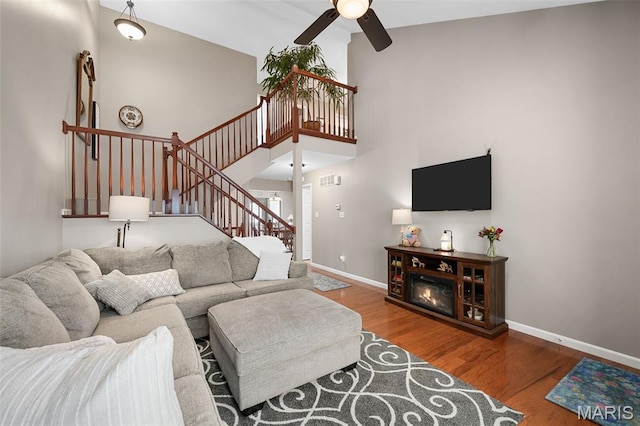 206 Belmonte Cir, Ofallon, MO 63368 - living area featuring a ceiling fan, wood finished floors, stairway, baseboards, and high vaulted ceiling