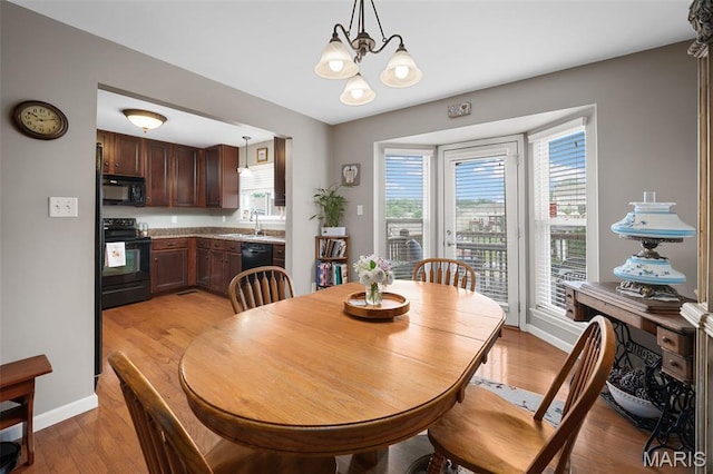 206 Belmonte Cir, Ofallon, MO 63368 - dining area with a chandelier, light wood-style floors, and baseboards