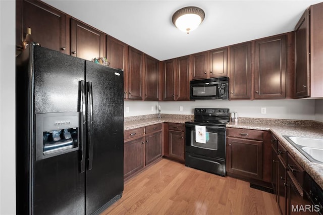 206 Belmonte Cir, Ofallon, MO 63368 - kitchen featuring black appliances, light wood-type flooring, dark brown cabinets, light countertops, and a sink