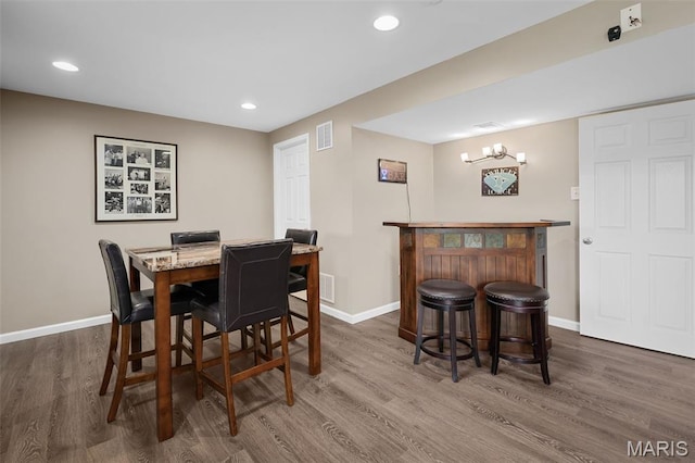 206 Belmonte Cir, Ofallon, MO 63368 - dining area with a bar, baseboards, dark wood-style floors, and recessed lighting