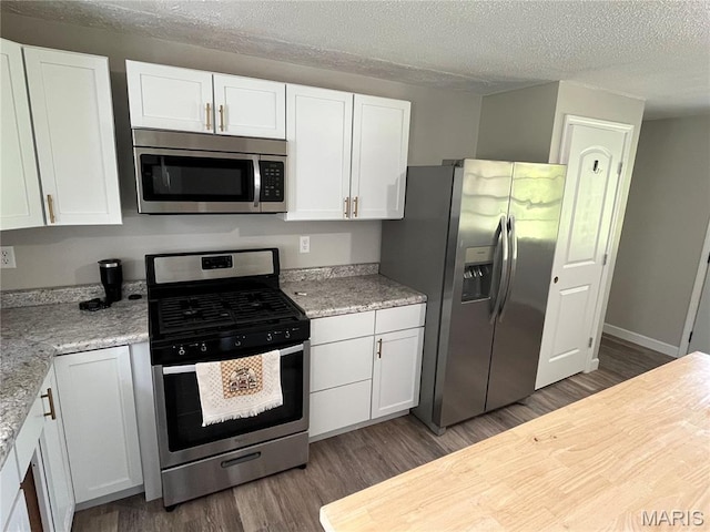 42 Davis Rd, Troy, MO 63379 - kitchen featuring appliances with stainless steel finishes, dark wood finished floors, white cabinetry, and a textured ceiling