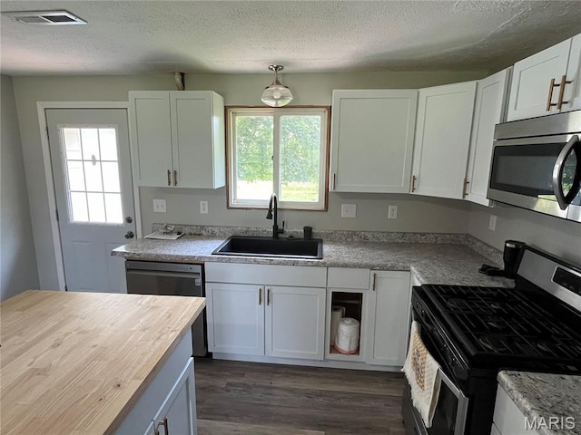 42 Davis Rd, Troy, MO 63379 - kitchen featuring appliances with stainless steel finishes, a textured ceiling, white cabinetry, dark wood-style floors, and butcher block counters