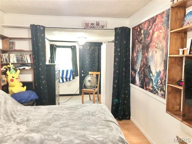 1003 W Ellis St, Salem, MO 65560 - bedroom featuring wood finished floors, baseboards, a textured ceiling, and access to exterior