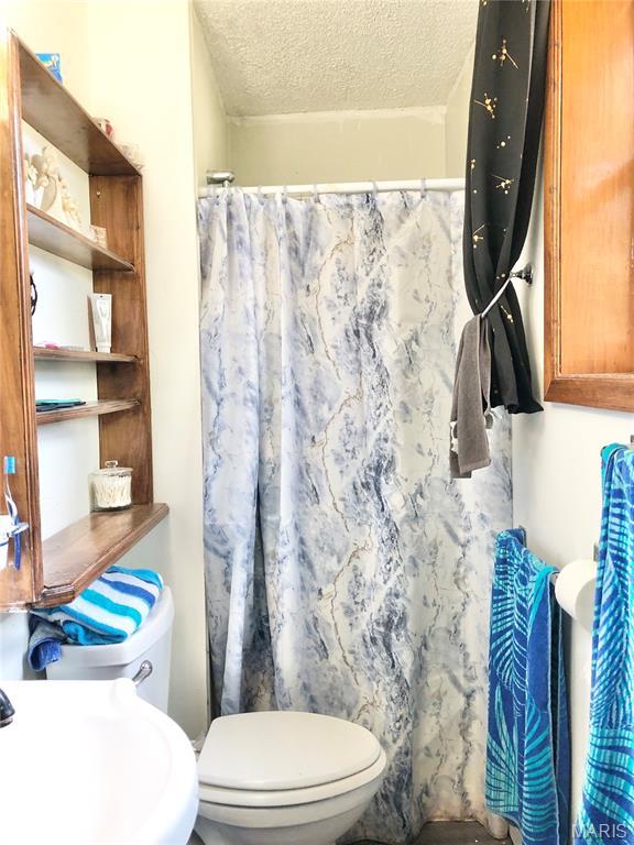 1003 W Ellis St, Salem, MO 65560 - full bathroom featuring toilet, a textured ceiling, and curtained shower