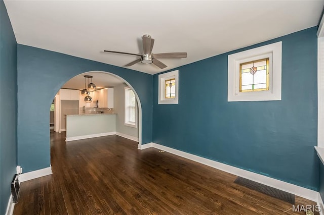 3271 Alfred Ave, Saint Louis, MO 63116 - unfurnished room with a ceiling fan, arched walkways, dark wood-style floors, and baseboards