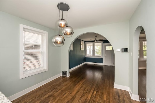 3271 Alfred Ave, Saint Louis, MO 63116 - unfurnished dining area featuring arched walkways, dark wood-style flooring, baseboards, and ceiling fan