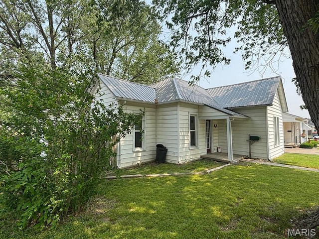 410 S Main St, Monroe City, MO 63456 - view of side of property with a lawn and a metal roof