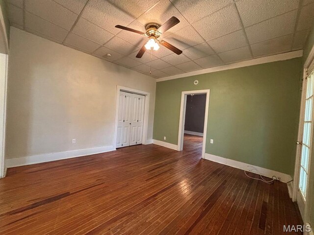 410 S Main St, Monroe City, MO 63456 - spare room with a drop ceiling, dark wood-type flooring, and a ceiling fan