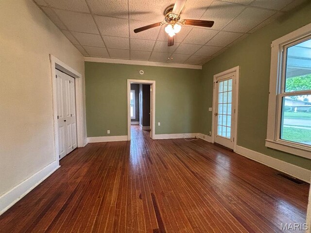 410 S Main St, Monroe City, MO 63456 - empty room with dark wood-style floors, a ceiling fan, and a drop ceiling