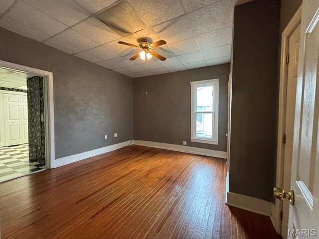 410 S Main St, Monroe City, MO 63456 - spare room with wood finished floors, a paneled ceiling, and ceiling fan