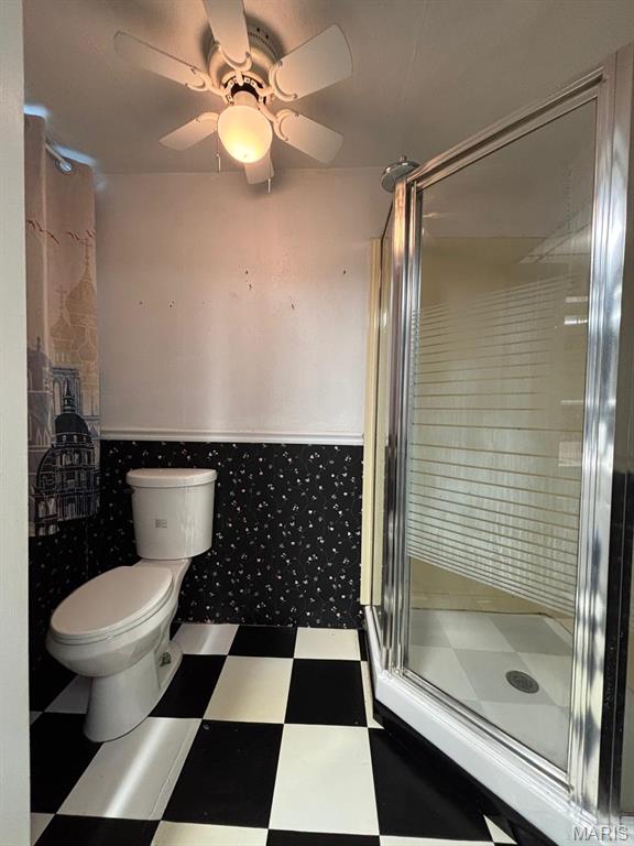 410 S Main St, Monroe City, MO 63456 - full bath with tile patterned floors, a shower stall, a wainscoted wall, a ceiling fan, and tile walls