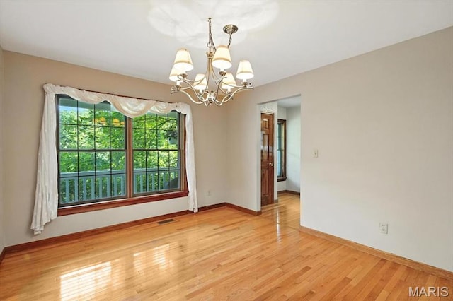 18232 Prickly Pear Ct, Pacific, MO 63069 - spare room featuring a chandelier and light wood-style flooring