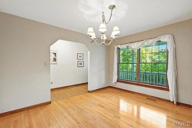 18232 Prickly Pear Ct, Pacific, MO 63069 - unfurnished room featuring a chandelier, light wood-style flooring, and arched walkways