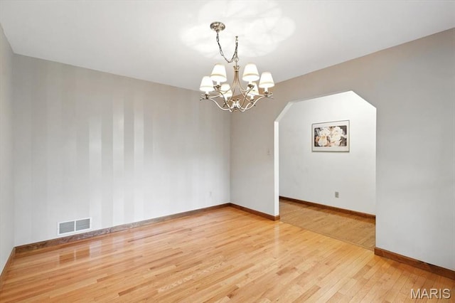18232 Prickly Pear Ct, Pacific, MO 63069 - unfurnished room with wood finished floors, a chandelier, and arched walkways