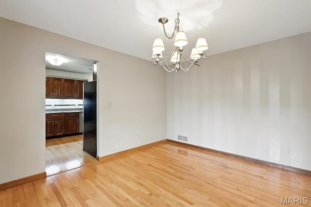18232 Prickly Pear Ct, Pacific, MO 63069 - empty room with a chandelier and light wood-style floors