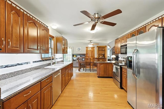 18232 Prickly Pear Ct, Pacific, MO 63069 - kitchen with stainless steel appliances, a ceiling fan, brown cabinetry, light wood-style flooring, and a peninsula