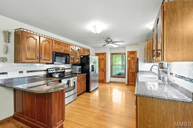 18232 Prickly Pear Ct, Pacific, MO 63069 - kitchen featuring electric stove, refrigerator with ice dispenser, black microwave, brown cabinetry, and dark stone counters