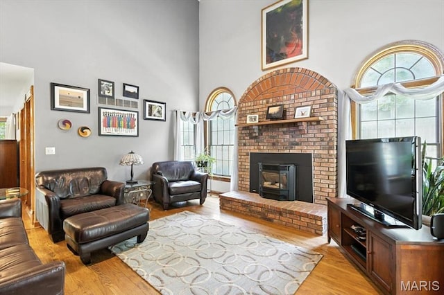 18232 Prickly Pear Ct, Pacific, MO 63069 - living room with light wood-style floors, healthy amount of natural light, a towering ceiling, and a brick fireplace
