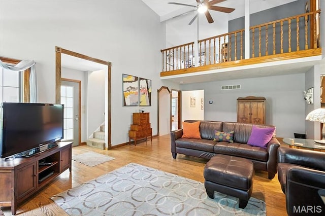 18232 Prickly Pear Ct, Pacific, MO 63069 - living room featuring a ceiling fan, stairway, light wood-style floors, and a high ceiling