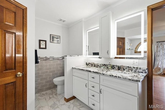 18232 Prickly Pear Ct, Pacific, MO 63069 - full bathroom featuring double vanity, tile walls, crown molding, marble look tiles, and a wainscoted wall