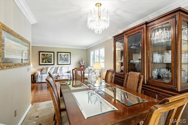 2342 Cedar Dale Ct, Maryland Heights, MO 63043 - dining space featuring ornamental molding, a chandelier, wood finished floors, and baseboards