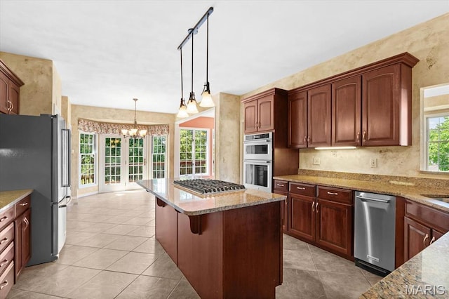 1609 10th Fairway Dr, Belleville, IL 62220 - kitchen featuring stainless steel appliances, a chandelier, light stone countertops, a kitchen island, and hanging light fixtures
