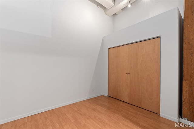 507 N 13th St Unit 207, Saint Louis, MO 63103 - unfurnished bedroom featuring light wood finished floors, rail lighting, and a closet