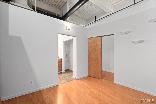 507 N 13th St Unit 207, Saint Louis, MO 63103 - unfurnished bedroom with a towering ceiling, light wood-type flooring, a closet, and ensuite bathroom