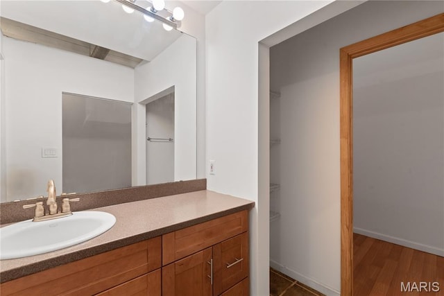 507 N 13th St Unit 207, Saint Louis, MO 63103 - bathroom featuring vanity, a spacious closet, and wood finished floors