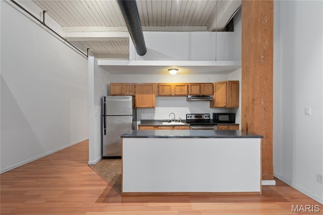 507 N 13th St Unit 207, Saint Louis, MO 63103 - kitchen with stainless steel appliances, extractor fan, dark countertops, light wood finished floors, and beamed ceiling