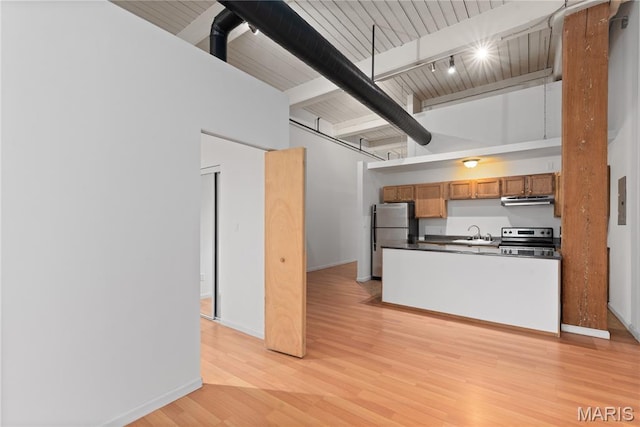 507 N 13th St Unit 207, Saint Louis, MO 63103 - kitchen with appliances with stainless steel finishes, ventilation hood, dark countertops, brown cabinets, and light wood finished floors