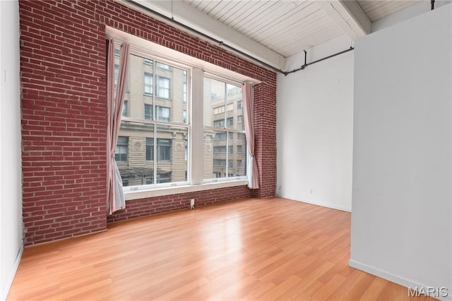 507 N 13th St Unit 207, Saint Louis, MO 63103 - unfurnished room with brick wall, wood finished floors, and a wooden ceiling with exposed beams