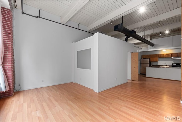 507 N 13th St Unit 207, Saint Louis, MO 63103 - unfurnished living room with light wood-style floors, beamed ceiling, and track lighting