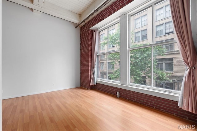 507 N 13th St Unit 207, Saint Louis, MO 63103 - spare room featuring brick wall, wood finished floors, and beam ceiling