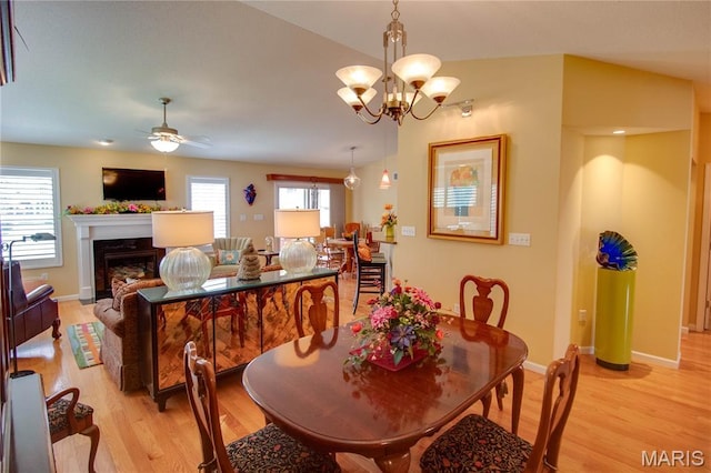 426 Vancroft Pl, Ofallon, IL 62269 - dining space with light wood-style floors, a ceiling fan, a fireplace, and a chandelier