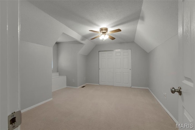 2280 Ebert Ln, Wentzville, MO 63385 - additional living space with a textured ceiling, light colored carpet, vaulted ceiling, and a ceiling fan