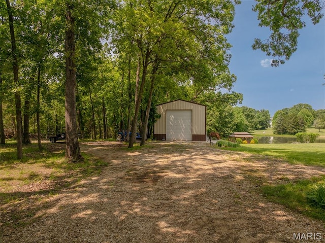11400 Macs Cove Dr, Wright City, MO 63390 - view of yard featuring dirt driveway, an outbuilding, a water view, and a detached garage