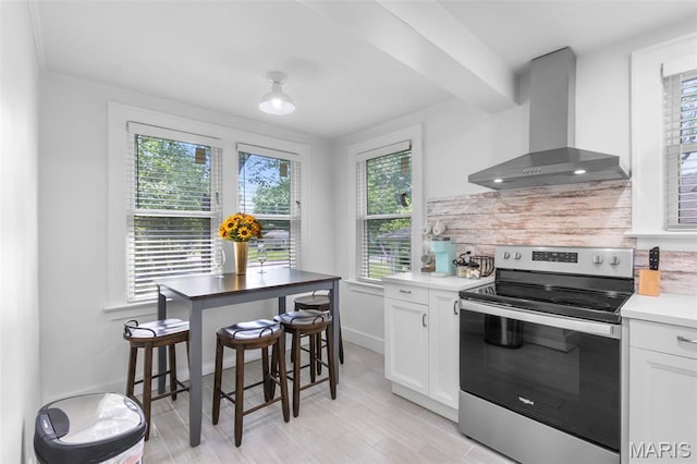 1210 Perryville Rd, Cape Girardeau, MO 63701 - kitchen featuring stainless steel electric range oven, wall chimney range hood, white cabinetry, and baseboards