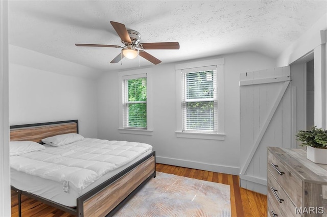1210 Perryville Rd, Cape Girardeau, MO 63701 - bedroom with a textured ceiling, wood finished floors, baseboards, a ceiling fan, and vaulted ceiling