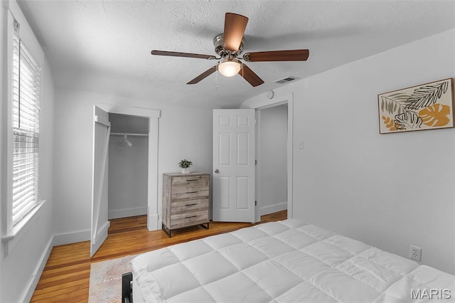 1210 Perryville Rd, Cape Girardeau, MO 63701 - bedroom featuring wood finished floors, a textured ceiling, a closet, baseboards, and ceiling fan
