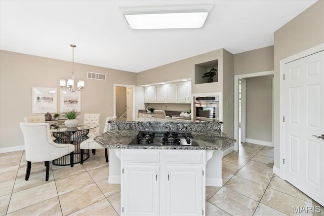 1525 Honey Locust Ct, Wildwood, MO 63005 - kitchen with gas cooktop, stainless steel oven, white cabinets, and light tile patterned floors