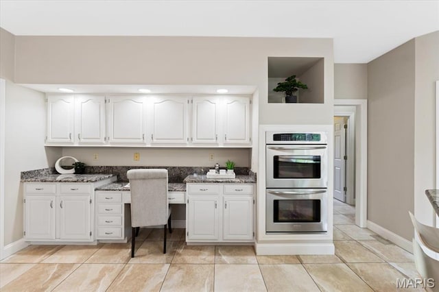 1525 Honey Locust Ct, Wildwood, MO 63005 - kitchen featuring double oven, white cabinetry, dark stone countertops, and light tile patterned flooring