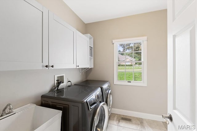 1525 Honey Locust Ct, Wildwood, MO 63005 - laundry area featuring cabinet space, washing machine and clothes dryer, and light tile patterned floors