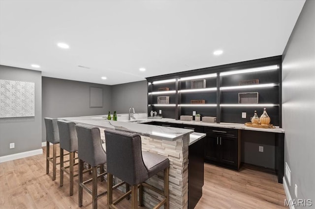 1525 Honey Locust Ct, Wildwood, MO 63005 - kitchen with a breakfast bar, light wood finished floors, light stone counters, open shelves, and recessed lighting