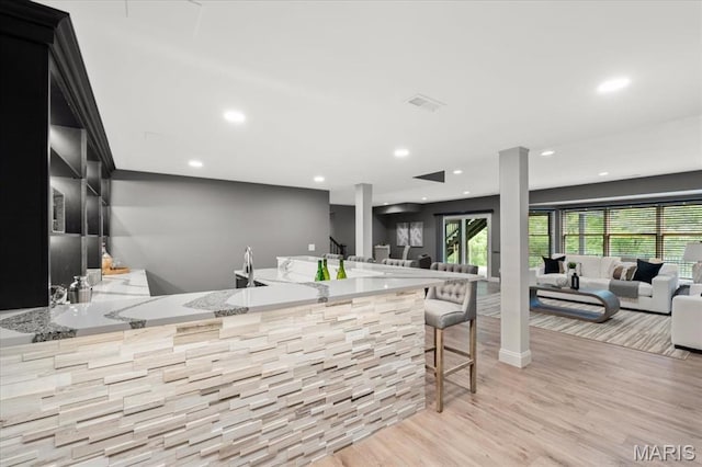 1525 Honey Locust Ct, Wildwood, MO 63005 - kitchen featuring light wood finished floors, open floor plan, recessed lighting, a peninsula, and a kitchen bar