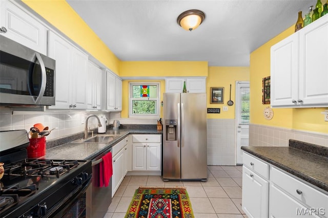 2604 Jonathan Dr, Mehlville, MO 63125 - kitchen featuring stainless steel appliances, white cabinetry, light tile patterned floors, tile walls, and wainscoting