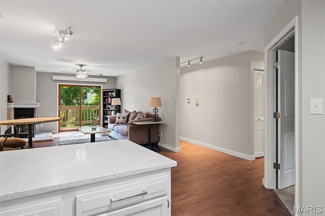 12958 Bryce Canyon Dr Unit C, Maryland Heights, MO 63043 - kitchen with rail lighting, a fireplace, a ceiling fan, white cabinets, and baseboards